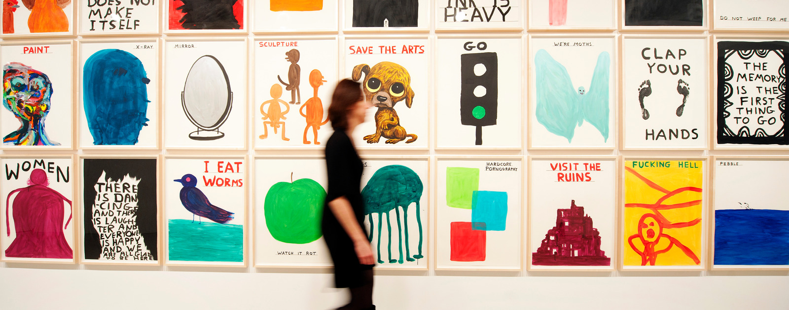 Violet Nights: Art and Activism Visitor walking past illustrations by David Shrigley at Hayward Gallery